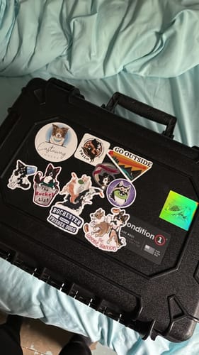 Customer's collection of custom vinyl dog stickers applied to a black hard case.