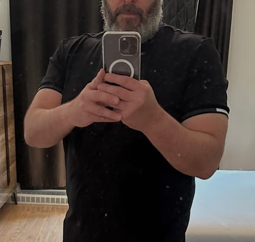 Gros plan d'un client portant le T-shirt Harden noir pour montrer la coupe sur son torse.
