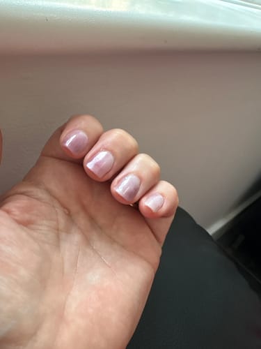 Reviewer's hand showing a Holy Gels manicure after 2.5 weeks with a sheer, pearlescent polish and no visible chipping.