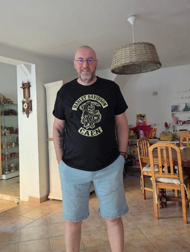 Client montrant le t-shirt noir avec un logo, mentionné dans son avis.