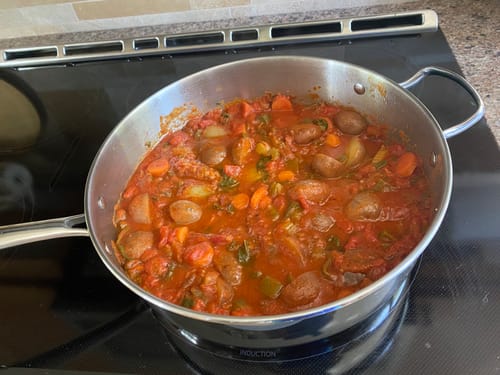 Customer's Swiss steak made from flank steaks simmering in a pan with potatoes and carrots.