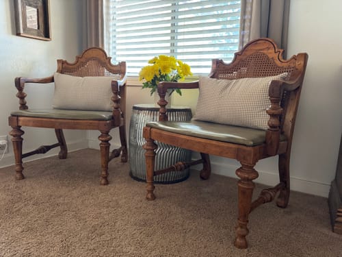 Customer's two tan gingham lumbar pillows on ornate wooden accent chairs.