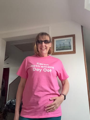Reviewer smiling in a customized pink unisex t-shirt with white text on the front for an outing.