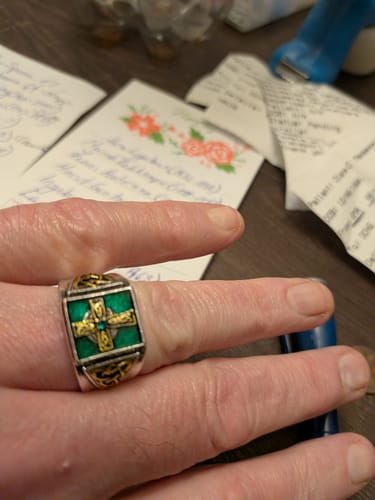 Reviewer wearing the silver Christianartworkshop ring with its green face and golden Celtic cross.