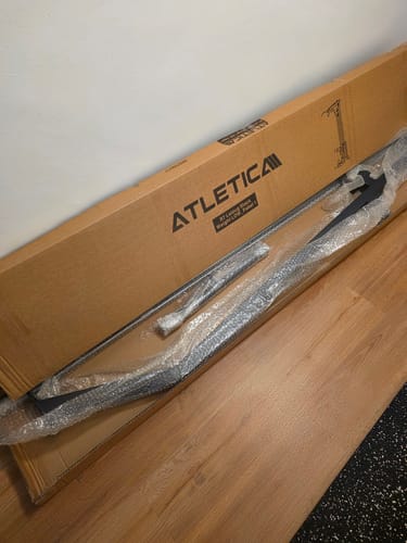 Rezensent zeigt den R7 Latzug Stack Weight in seiner großen Originalverpackung beim Auspacken.