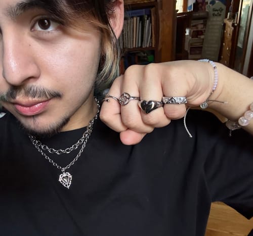 Close-up of a reviewer wearing the silver Astrology Ring on their index finger with several other rings.