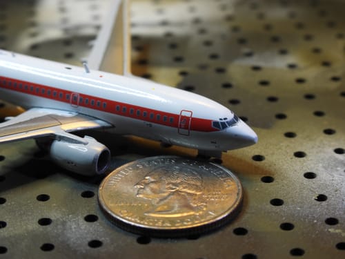 Close-up of the reviewer's detailed JANET 737-600 model next to a quarter, showing its small scale.