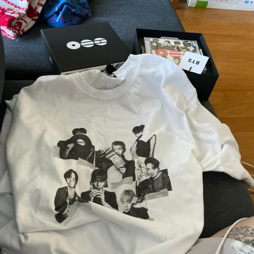 Customer's BTS album t-shirt and CD box set laid out. The white shirt features a black-and-white graphic of the band.