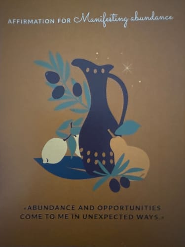 Customer's affirmation card from the VIP Crystal Club reading, "Abundance and opportunities come to me in unexpected ways."