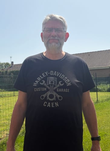 Un client portant le T-shirt Custom Garage noir en extérieur, avec le motif graphique visible sur le torse.