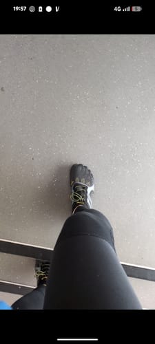 Customer's first-person view of their black Fast Ⅰ - Barefoot Shoes with green laces, worn at a gym.