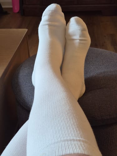 Reviewer relaxing with their feet up, wearing the white ribbed Eucalyptus Lyocell Compression Socks.