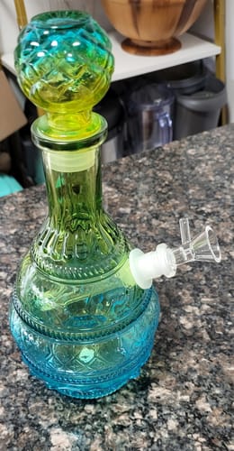 Reviewer's blue and green Vintage Ombre Glass Vase Water Pipe sitting on a dark countertop.