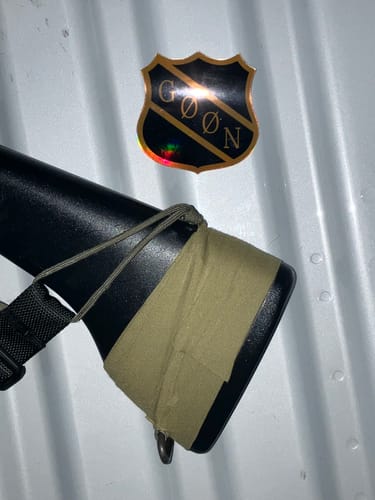 Close-up of a reviewer's rifle stock with OD Green Raid Tape wrapped around the butt.