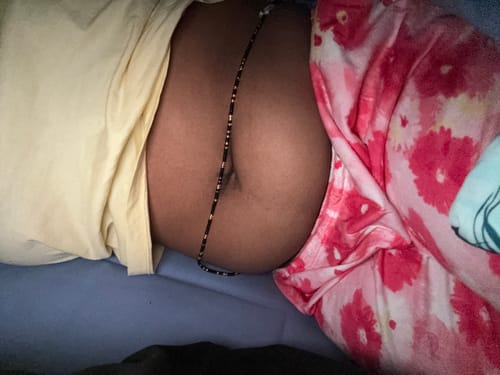 Customer lying down showing the black and gold tie-on waist beads around their midsection.
