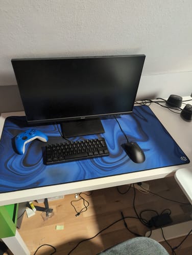 Kunde zeigt sein RZ Mousepad Liquid Blue auf einem Schreibtisch mit Tastatur und Controller.