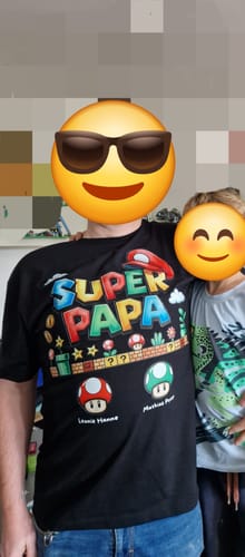Rezensent trägt das personalisierte schwarze Super Papa T-Shirt neben einem Kind.