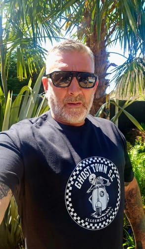 Reviewer wearing a black unisex t-shirt with a large, white circular graphic printed on the front.
