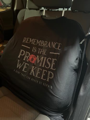 Customer's 'The Promise We Keep' t-shirt with a memorial design draped over a car's headrest.