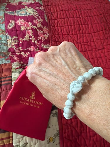 Customer wearing a white, heart-shaped Howlite bracelet from the VIP Crystal Club on their wrist.