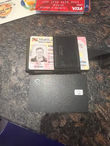 Reviewer's black Tracking card on a countertop next to a wallet with other cards.