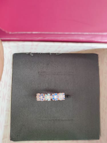 Customer's Rose Gold Glinting Crown Ring with blue and clear stones shown in its presentation box.