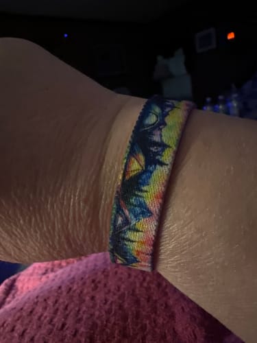 Close-up of a reviewer wearing the Trust Your Compass Bracelet, showing the colorful camping design.