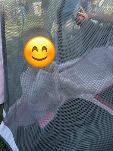 Customer's baby playing inside the dark mesh Pop 'N Go Playpen outdoors.