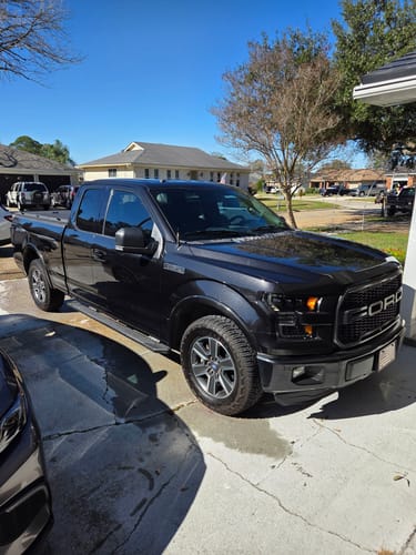 Customer's shiny black truck in a driveway, showing the glossy results of the Vionyx Ceramic Protectant.