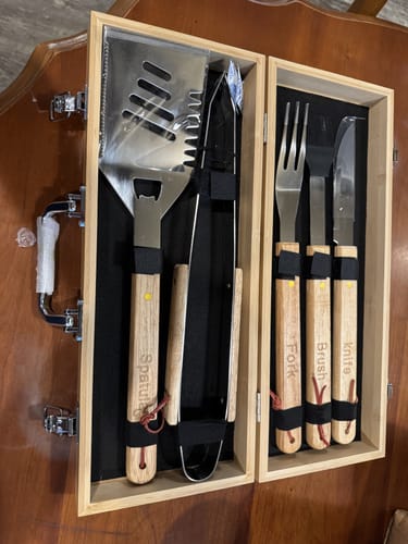 Reviewer's 5-piece stainless BBQ set with wooden handles neatly arranged in its wooden presentation box.