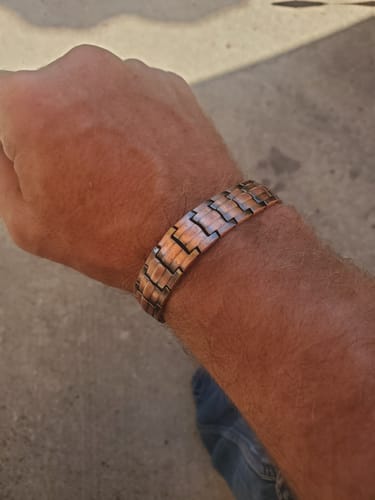 A customer's wrist showing the detailed copper links of the Vitalis Copper Magnetic Bracelet.