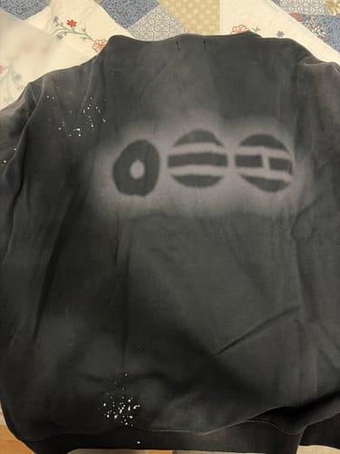 Customer's black BTS Arirang hoodie laid flat, showing the faded graphic design on the back.