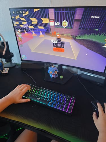 Kundenfoto der RZ Gaming-Tastatur mit bunter Beleuchtung, die eine Person beim Spielen verwendet.