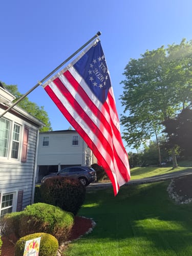 Customer's commemorative '1776 2026' American flag flying on a flagpole in front of a house.
