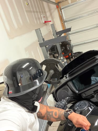 Side view of a reviewer wearing the gloss black Germanator Helmet, showing its fit while on a motorcycle.