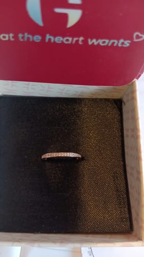 Customer's Rose Gold Zircon Channel of Love Ring resting flat in its open red and white presentation box.