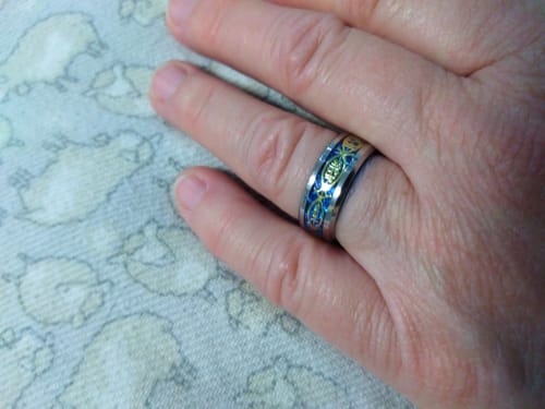 Reviewer's hand wearing the ornate blue and silver 'Jesus' in Fish stainless steel ring.