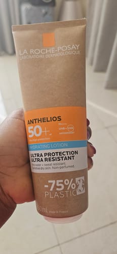 Reviewer holding the La Roche-Posay Anthelios Hydrating Lotion in its distinct cardboard-style tube.