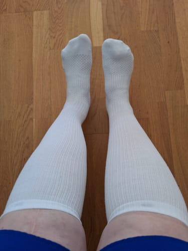 Recensentens ben med de vita Diasocks tunna stödstrumporna, sedda uppifrån.