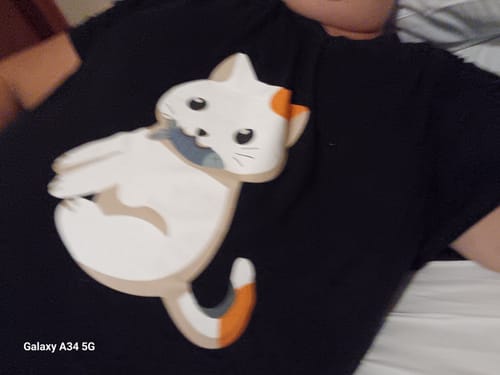 Cliente mostra um close-up da estampa de gato na sua Camisola Gatinho preta.