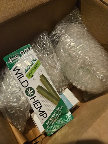 Customer's unboxing of the Mystery Box, showing bubble-wrapped items and a pack of hemp wraps in a shipping box.
