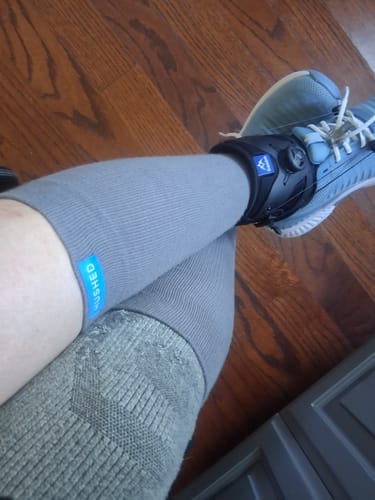 Customer wearing grey Eucalyptus Lyocell Compression Socks with an ankle brace and shoe.