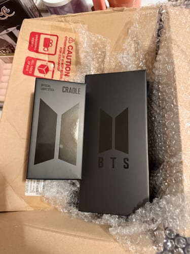 Customer's packaging for the BTS Official Light Stick Ver.4 and Cradle, just unboxed from a shipping container.