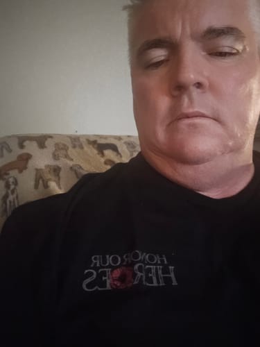 A customer wearing the black 'The Promise We Keep' t-shirt with the 'Honor Our Heroes' graphic.