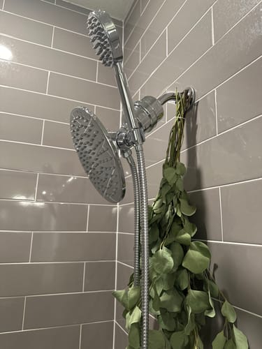Customer's installed chrome 1-Spray Dual Shower Head Set with a filter against grey tiled shower walls.