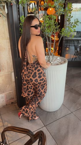 Customer wearing the leopard print Naked Print Halter Wide Leg Jumpsuit, showing the open-back design.