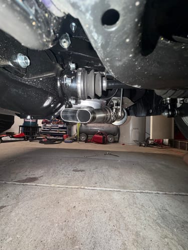 Customer's view of the stainless steel oval exhaust tube installed underneath a vehicle, showing clearance.