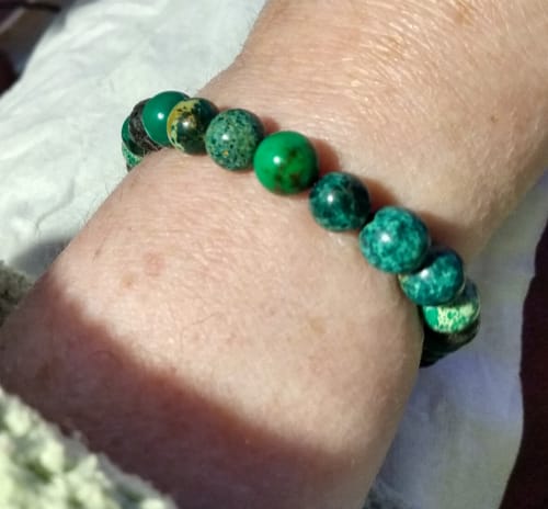 Customer's close-up of the Phoenix Rising Bracelet, showing green patterned beads on their wrist.