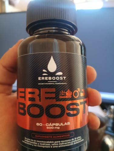 Un cliente sostiene en su mano el frasco negro del suplemento Ereboost.