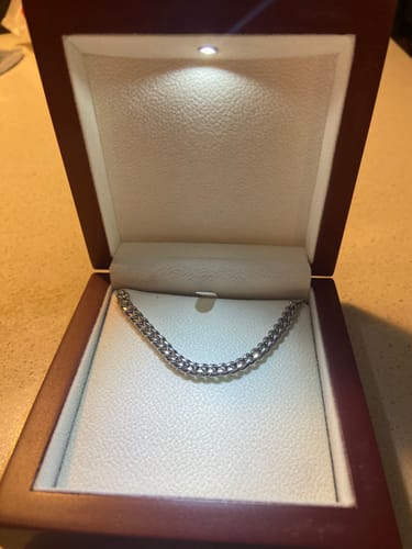 Customer's Cuban Link Chain displayed in a lighted, mahogany-style gift box.